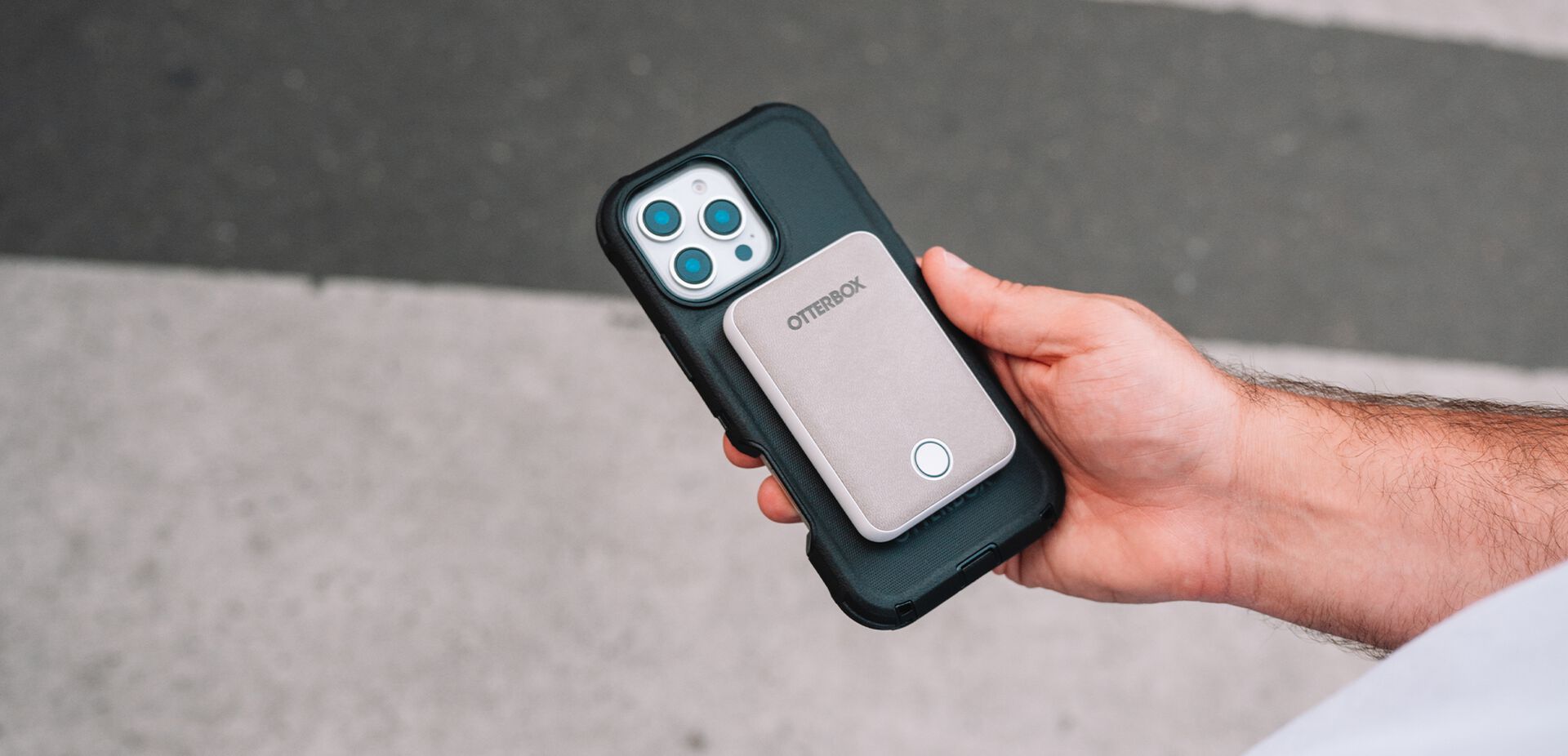 Person holding a phone with a case featuring the brand 'Onn' against a blurred background.