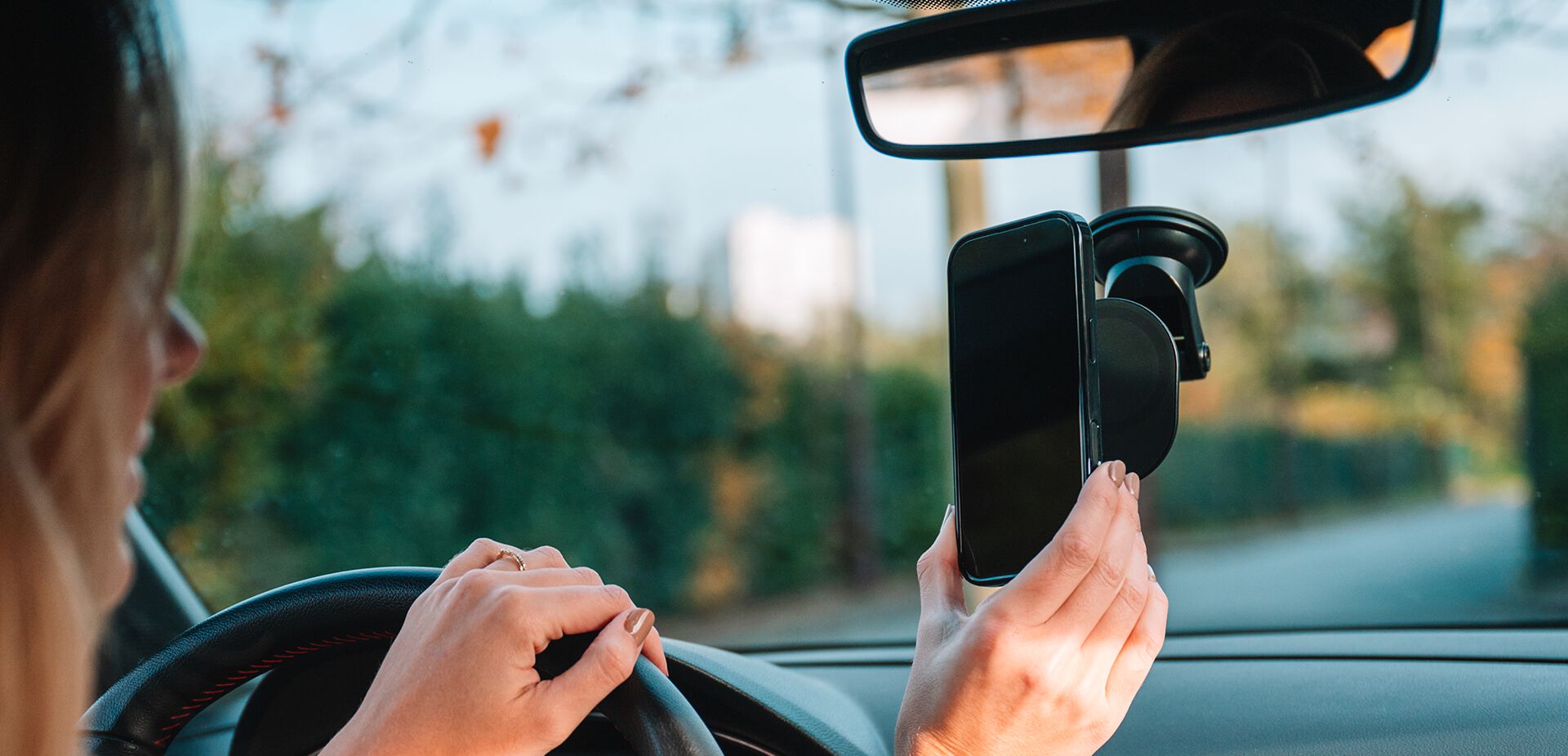 Person using a smartphone with a car mount in a vehicle