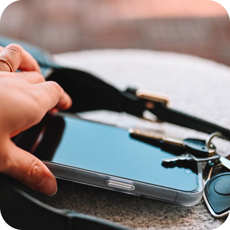 Person holding a smartphone with keys on the screen