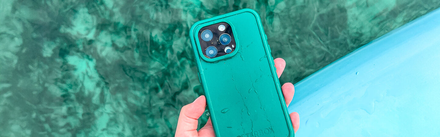 Person holding a teal phone case with water on the case
